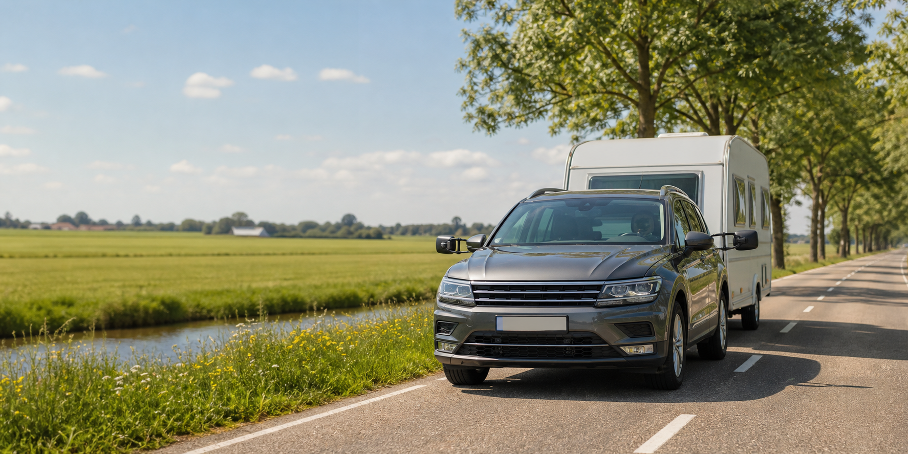 Auto met caravan en caravanspiegels op een zonnige weg